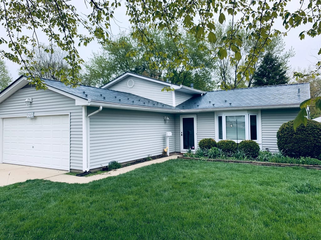 Deep Charcoal Interlock Slate aluminum roof on a light grey ranch home with a metal roof among lush, Elgin, Illinois