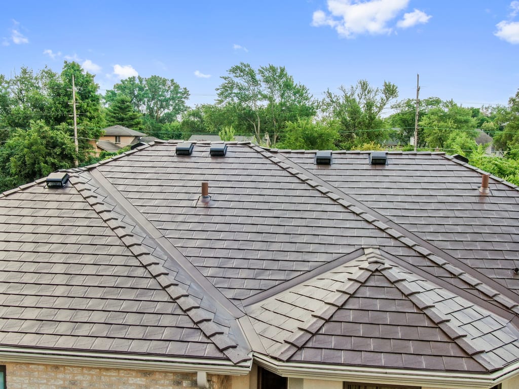 Colonial Brown Interlock Slate aluminum roof on a brown Colonial home with dormers among tall green trees, Calredon Hills, Illinois