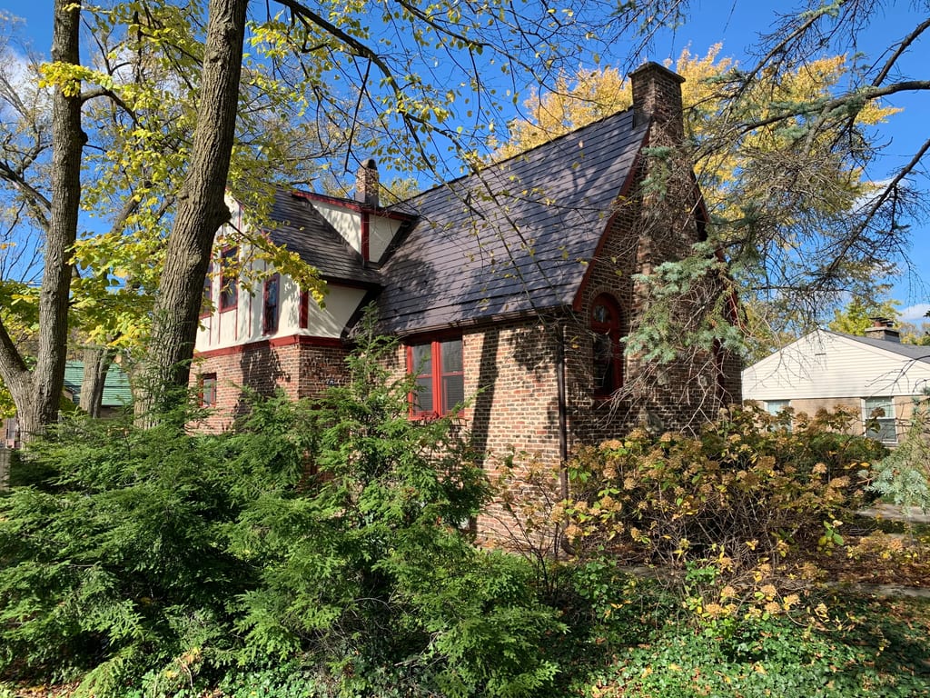 Tudor Brown Interlock Slate aluminum roof on a red brick Tudor home with a slate metal roof amidst, Elmhurst, Illinois