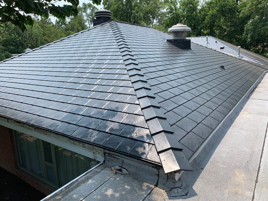 Black Interlock Slate aluminum roof on a brick single-family home with dormers among tall trees, Flossmoor, Illinois