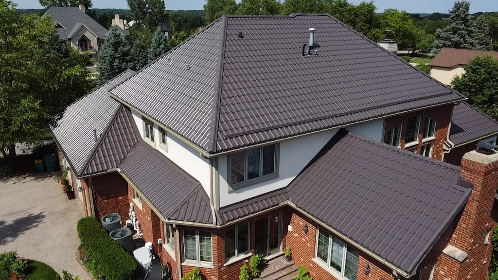 Tudor Brown Interlock Tile aluminum roof on a Tudor Brown metal roof on a colonial home in a forested, Lemont, Illinois