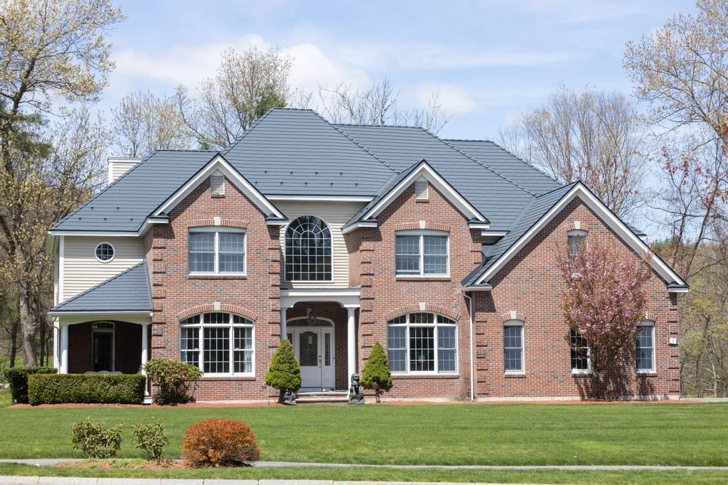 Deep Charcoal Interlock Cedar Shingle aluminum roof on a red brick two-storey colonial home with dormers among, Westford, Massachusetts