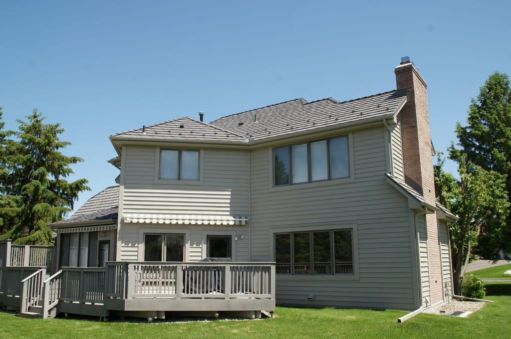 Weathered Interlock Shake aluminum roof on a two-storey Colonial home with a chimney in a forested, Mendota Heights, Minnesota