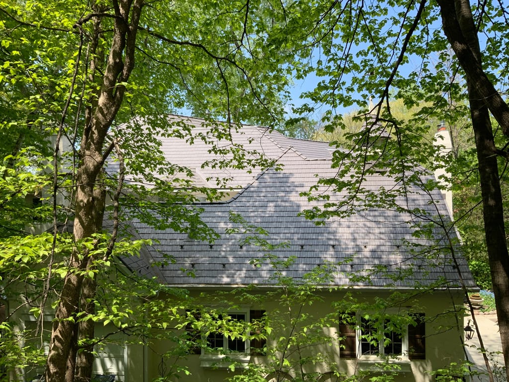 Weathered Interlock Cedar Shingle aluminum roof on a two-storey home with dormers in a forest, Shorewood, Minnesota