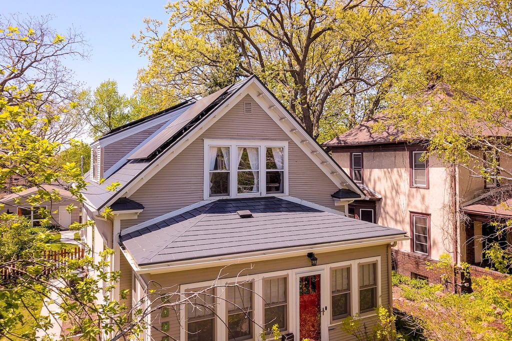 Deep Charcoal Interlock Slate aluminum roof on a beige single-family home with a grey metal roof among, Minneapolis, Minnesota