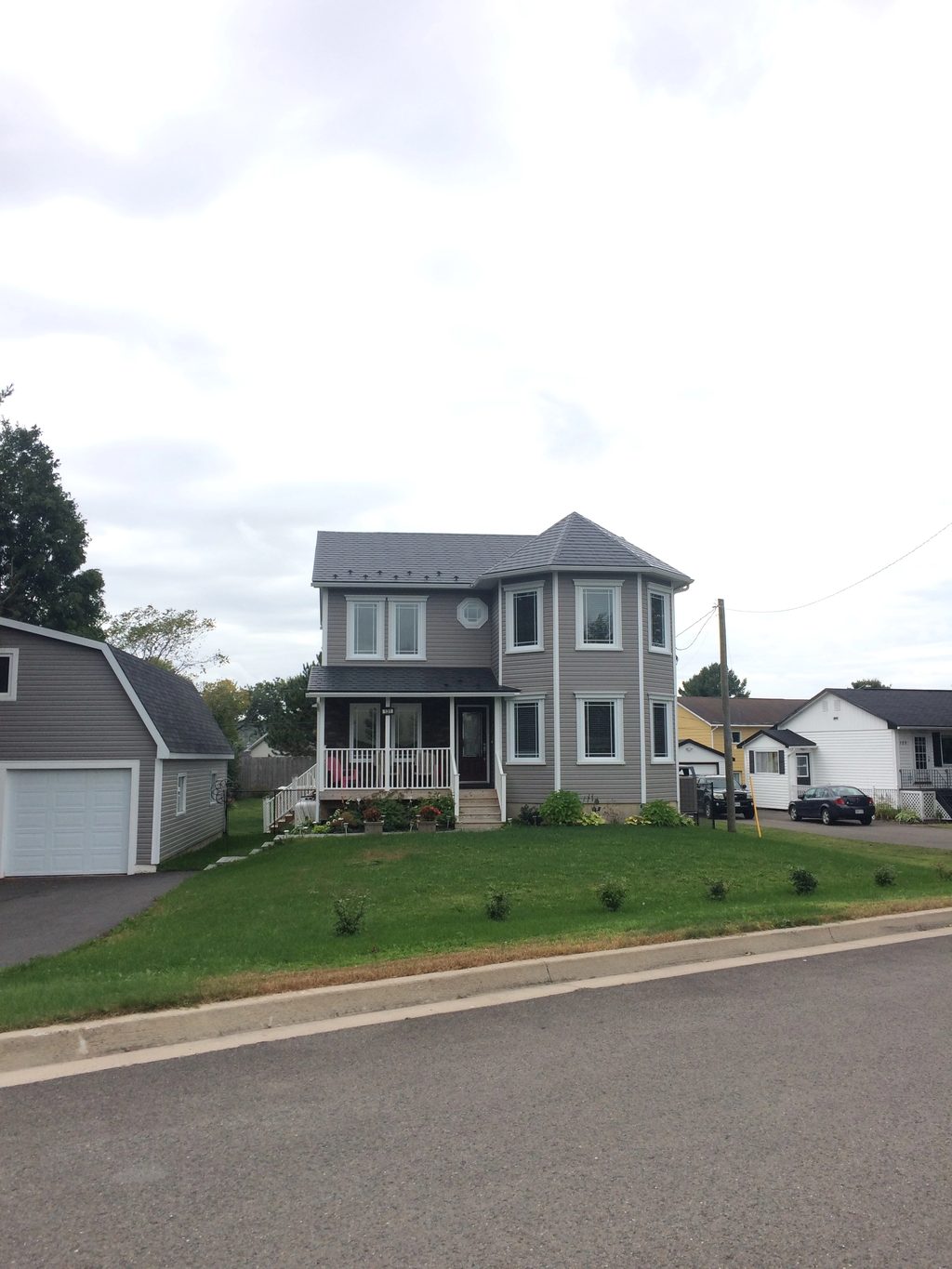 Black Interlock Slate aluminum roof on a grey two-storey home with a metal roof under construction, Fredericton, New Brunswick