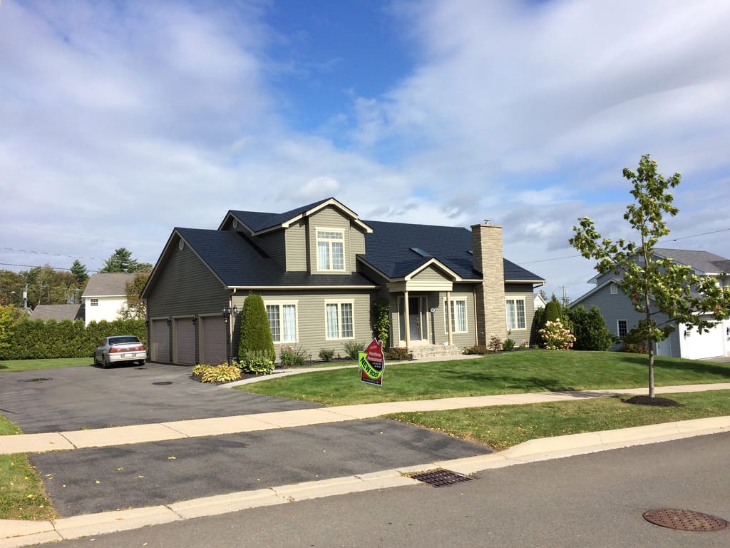 Black Interlock Slate aluminum roof on a beige Colonial home with a black metal roof and chimney, Fredericton, New Brunswick