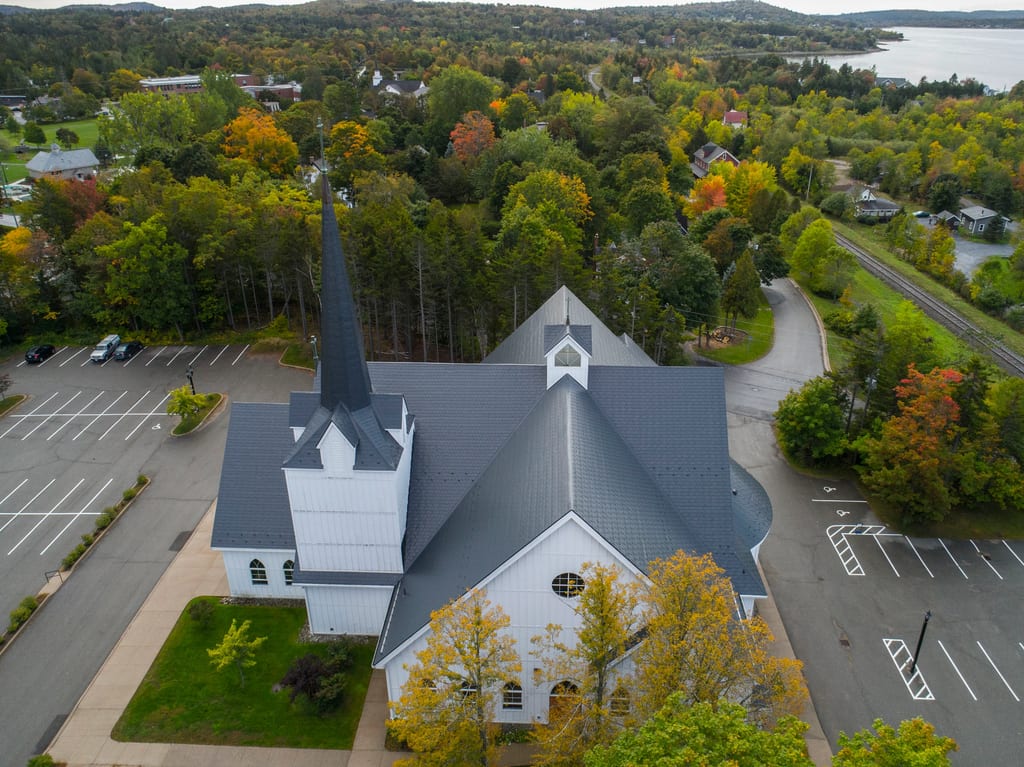 Deep Charcoal Interlock Slate aluminum roof on a church with a deep charcoal metal roof in a forested, Rothesay, New Brunswick