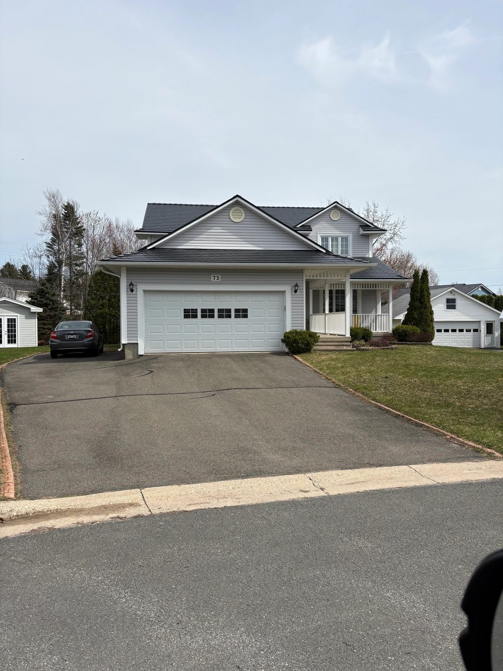 Black Interlock Slate aluminum roof on a white single-family home with a grey metal roof in a, Fredericton, New Brunswick