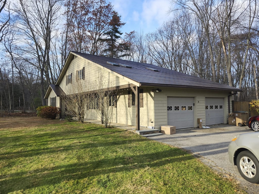 1.5-story single-family home in Atkinson NH with Interlock Colonial Brown aluminum shingle roof, skylights, solar panels, and two-car garage.