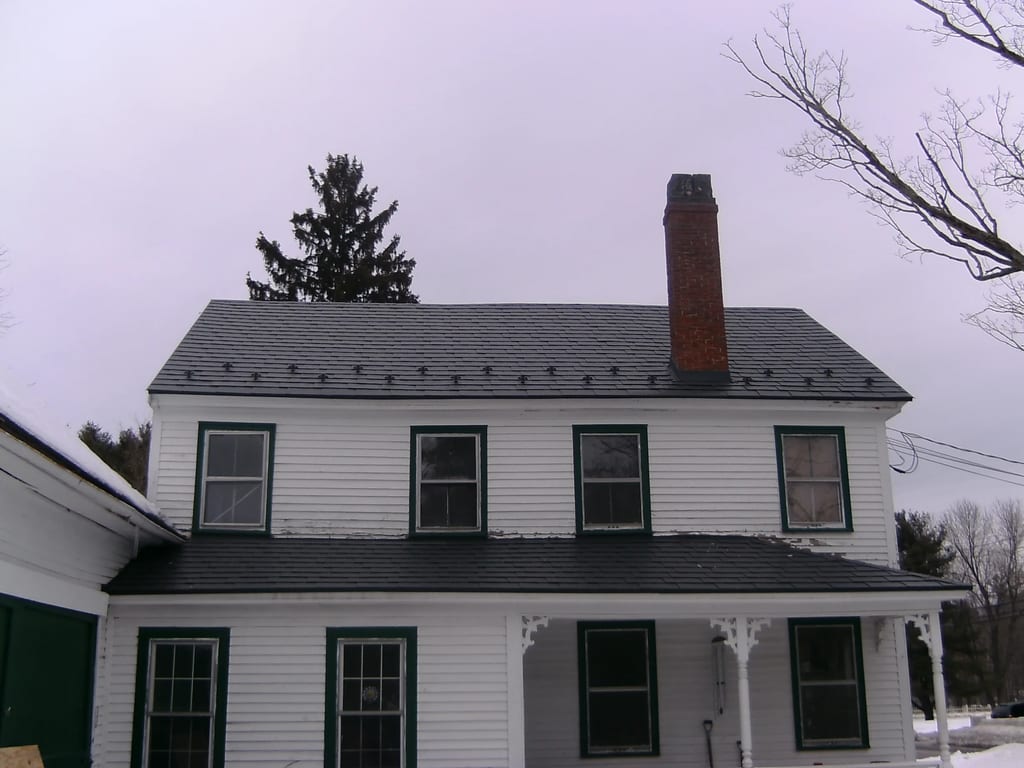 Charcoal Grey Interlock Slate aluminum roof on a white colonial home with a covered porch in a rural, Windham, New Hampshire