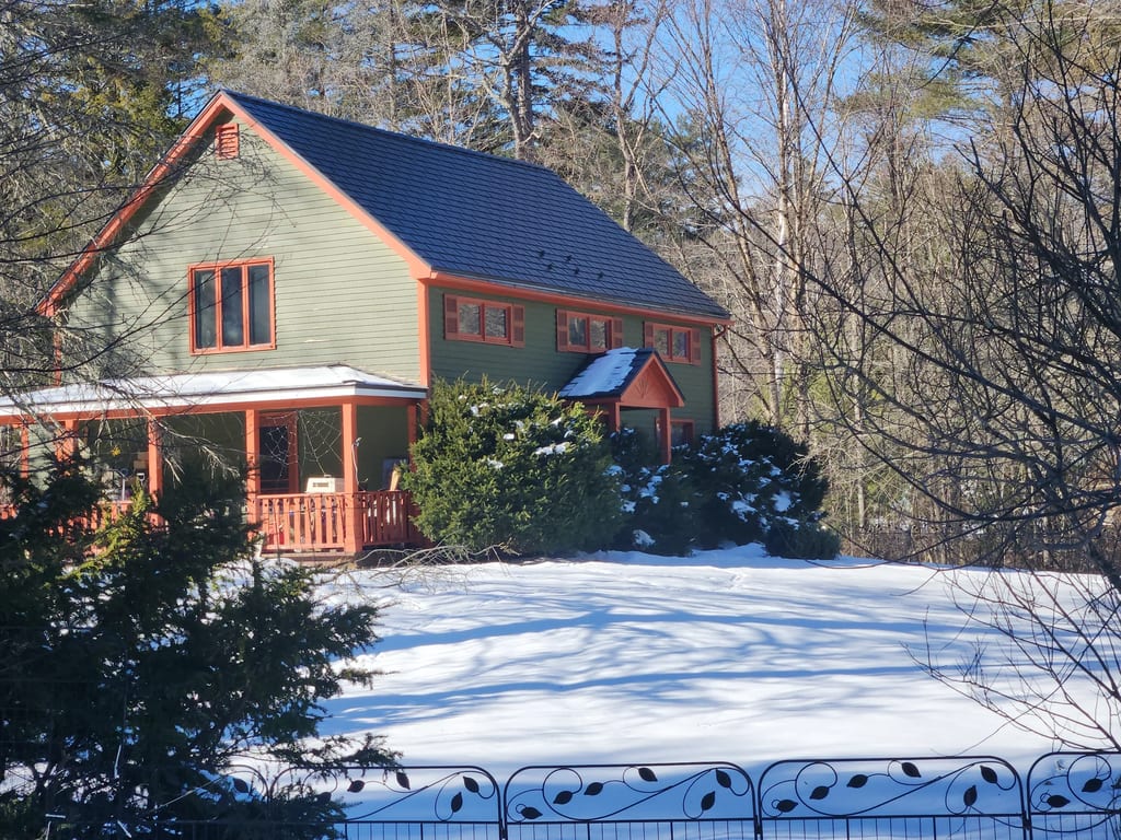 Deep Charcoal Interlock Slate aluminum roof on a colonial home with a slate metal roof in a forested rural, Wilmot, New Hampshire