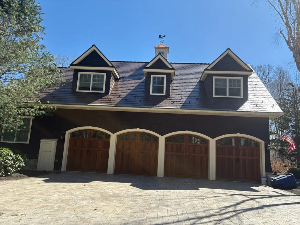 Colonial Brown Interlock Slate aluminum roof on a brown Colonial home with dormers among tall trees, Concord, New Hampshire