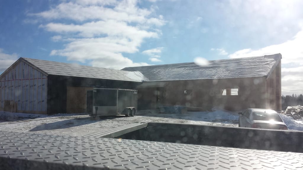 Deep Charcoal Interlock Standing Seam aluminum roof being installed on the home, Cow Bay, Nova Scotia