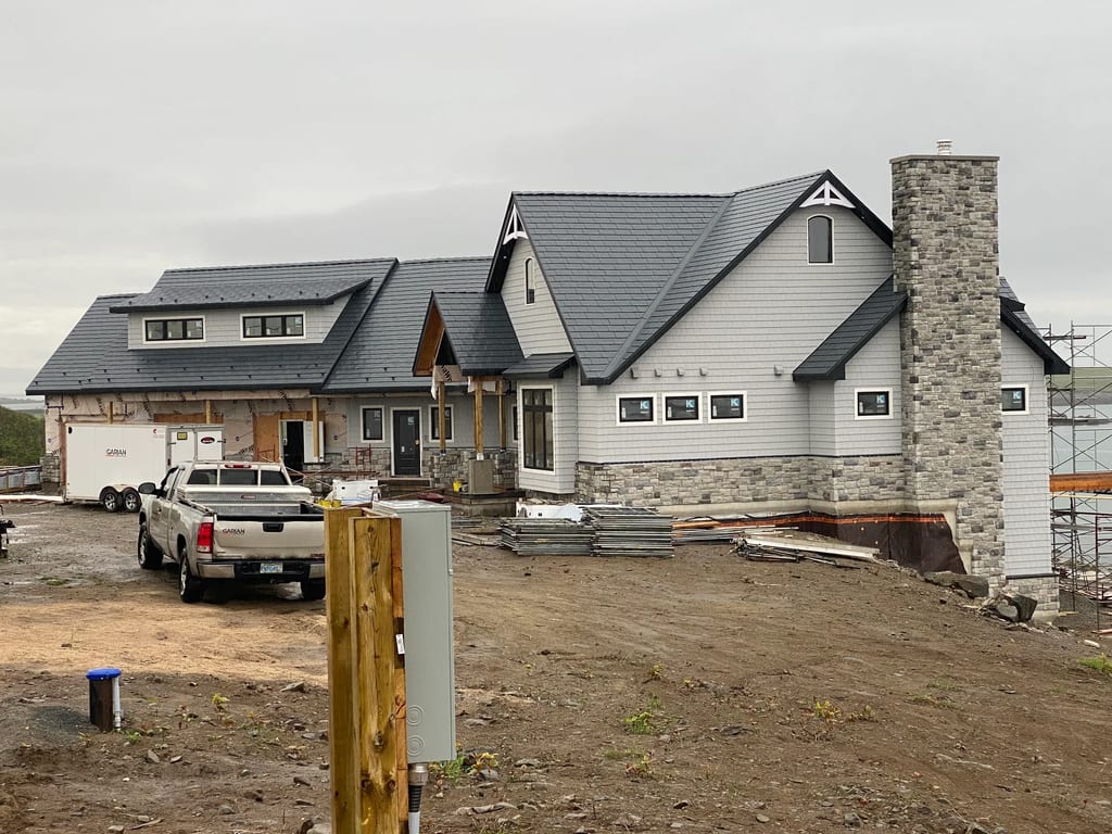 Deep Charcoal Interlock Slate aluminum roof being installed on the home, Sand Beach, Nova Scotia