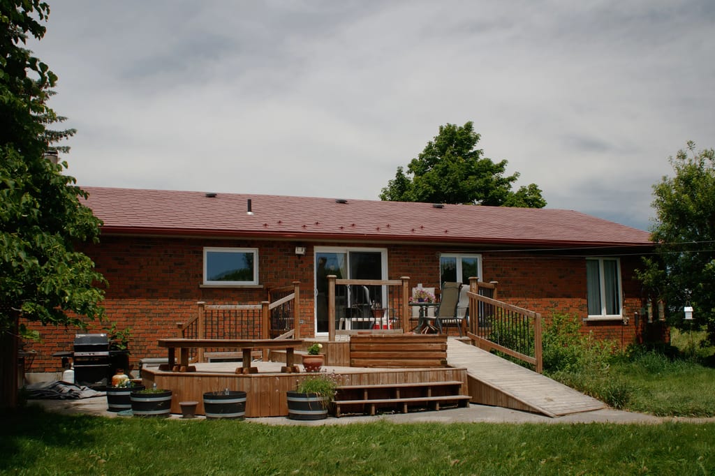 Tile Red Interlock Shingle aluminum roof on a red brick ranch with a brown roof and front porch, Orangeville, Ontario