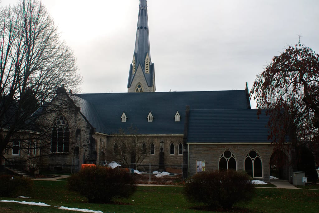 Charcoal Grey Interlock Slate aluminum roof on a tan brick church with a metal roof among trees in a rural, Owen Sound, Ontario