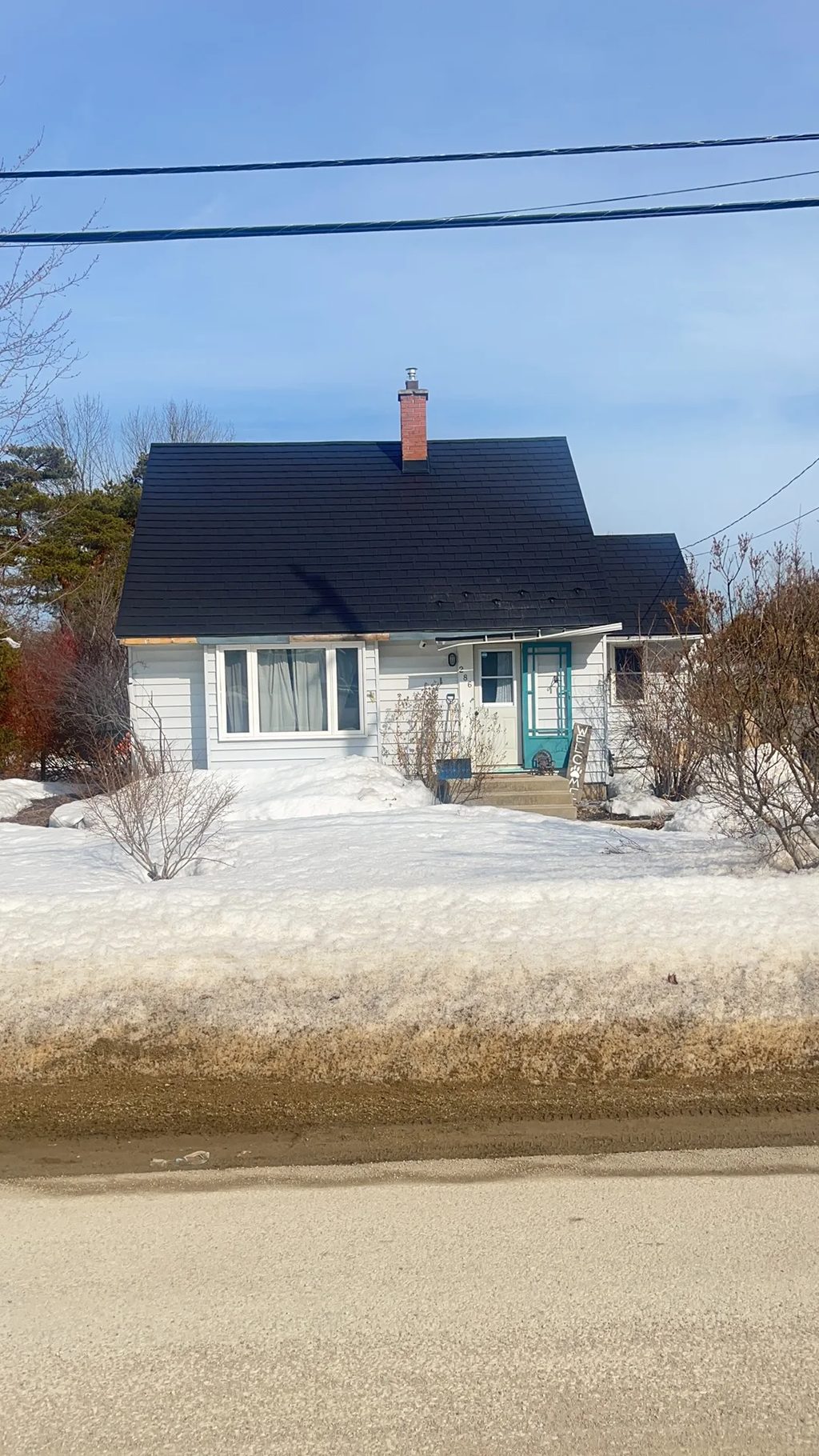Black Interlock Slate aluminum roof on a white home with a black metal roof in a snowy rural, Meaford, Ontario