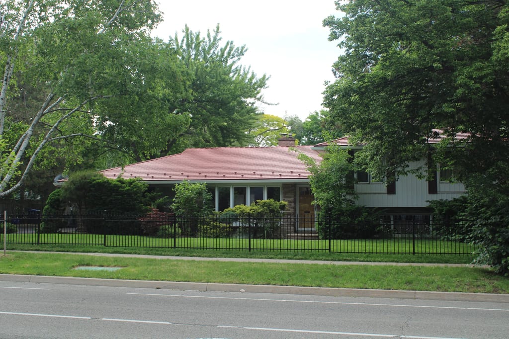 Tile Red Interlock Cedar Shingle aluminum roof on a red roofed home among tall trees in a suburban, Mississauga, Ontario