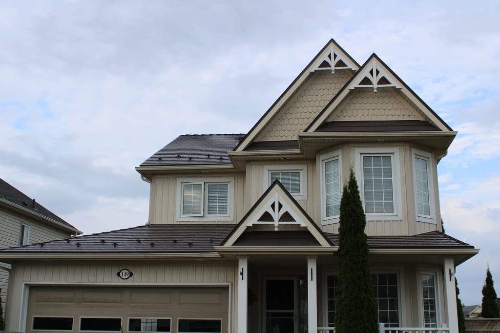 Tudor Brown Interlock Cedar Shingle aluminum roof on a beige two-storey home with dormers in a suburban, Shelburne, Ontario