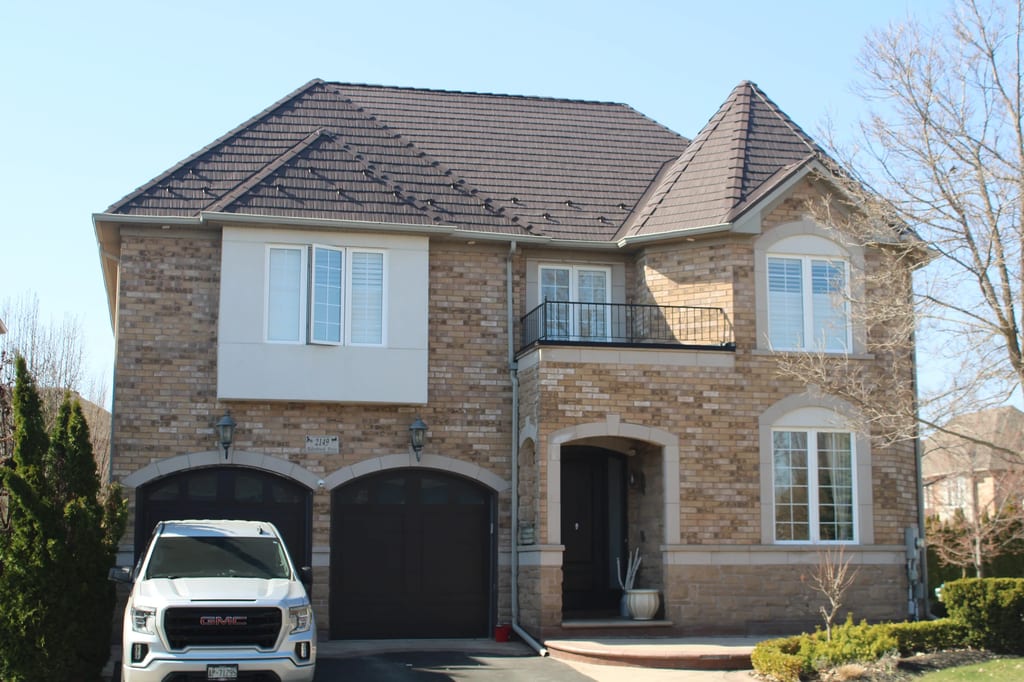 Tudor Brown Interlock Cedar Shingle aluminum roof on a brown two-storey Tudor home with dormers in a lush, Oakville, Ontario