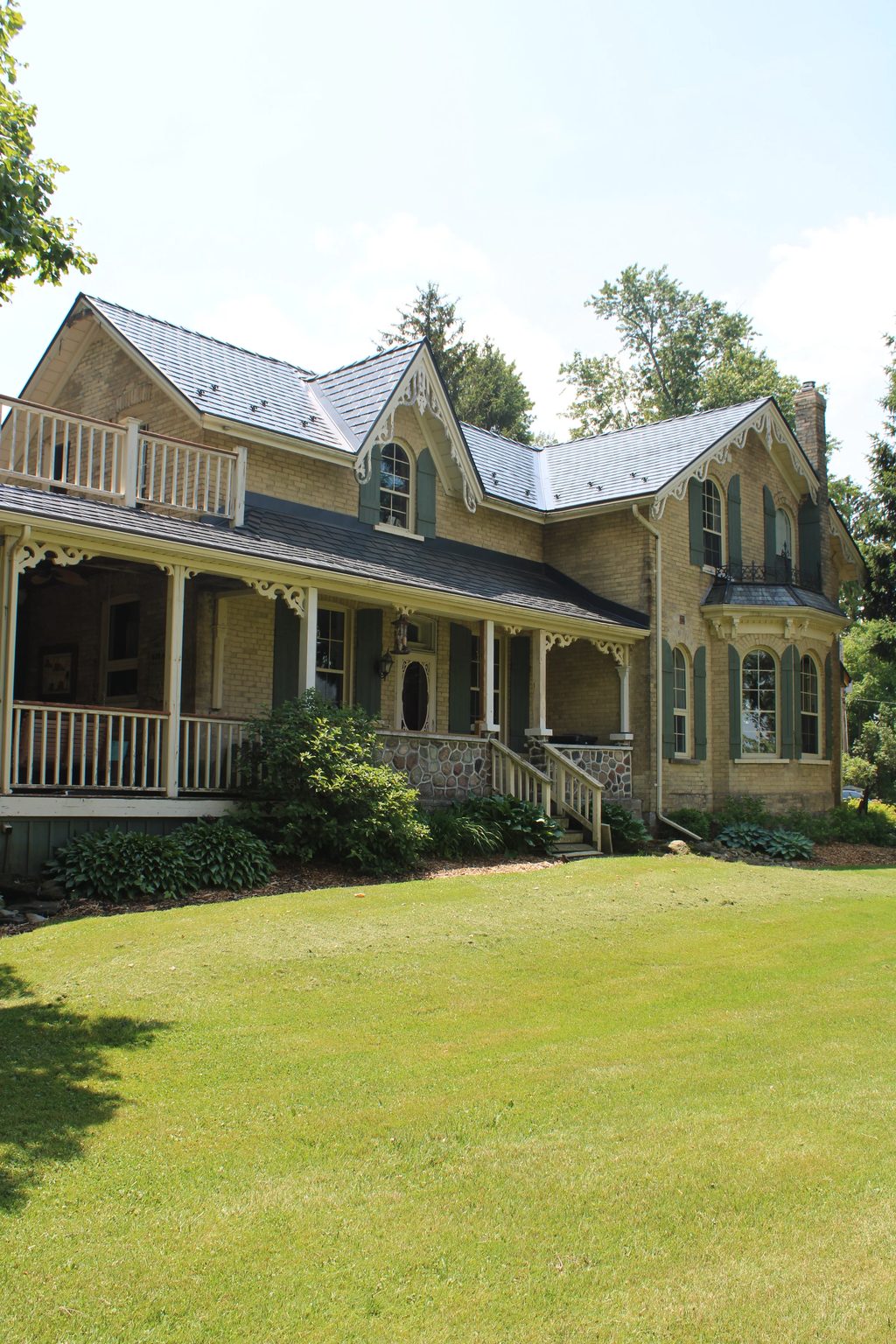 Deep Charcoal Interlock Cedar Shingle aluminum roof on a tan two-storey Victorian home with dormers in a forested, Thorndale, Ontario