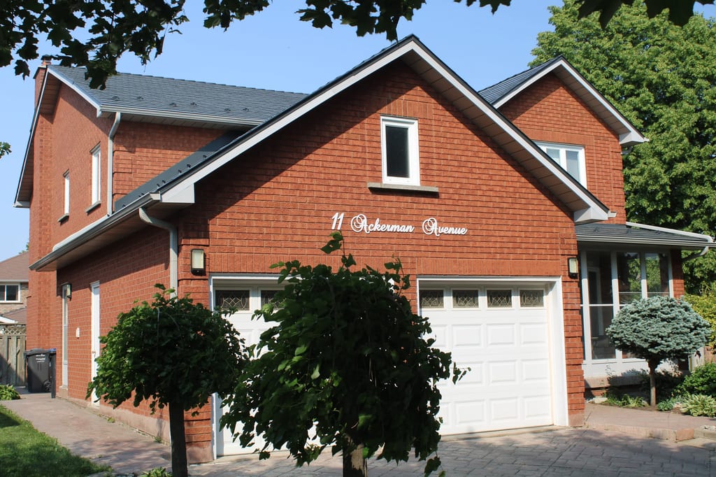 Deep Charcoal Interlock Cedar Shingle aluminum roof on a brick two-storey home with a garage and dormers in a, Brampton, Ontario