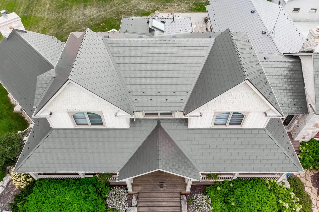 Aerial drone view of a complex multi-hip Interlock aluminum cedar shingle roof in Tudor Brown on a large Craftsman-style home in Pefferlaw, ON.