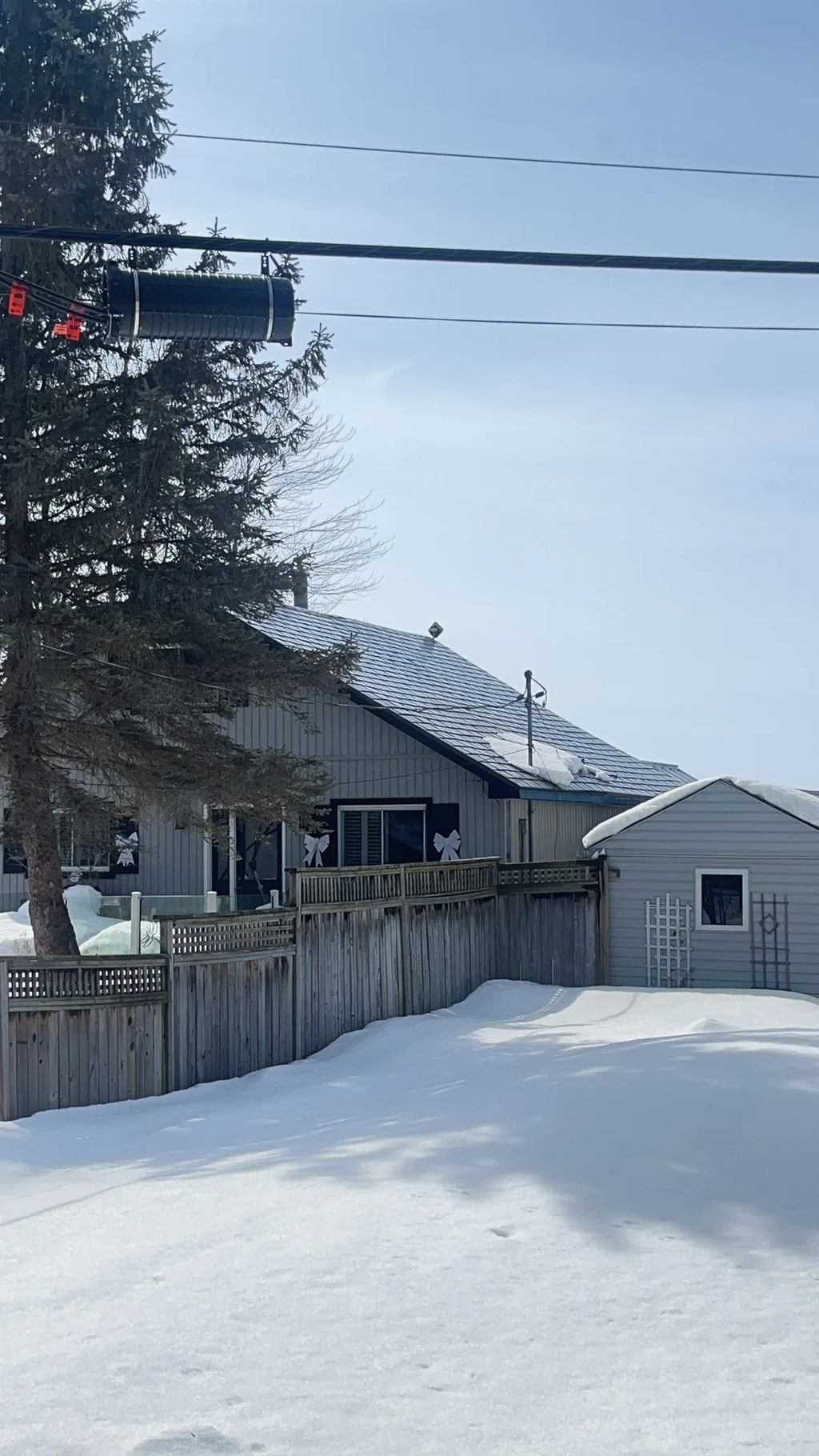 Deep Charcoal Interlock Slate aluminum roof on a grey single-family home with a metal roof in a snowy, Ramara, Ontario