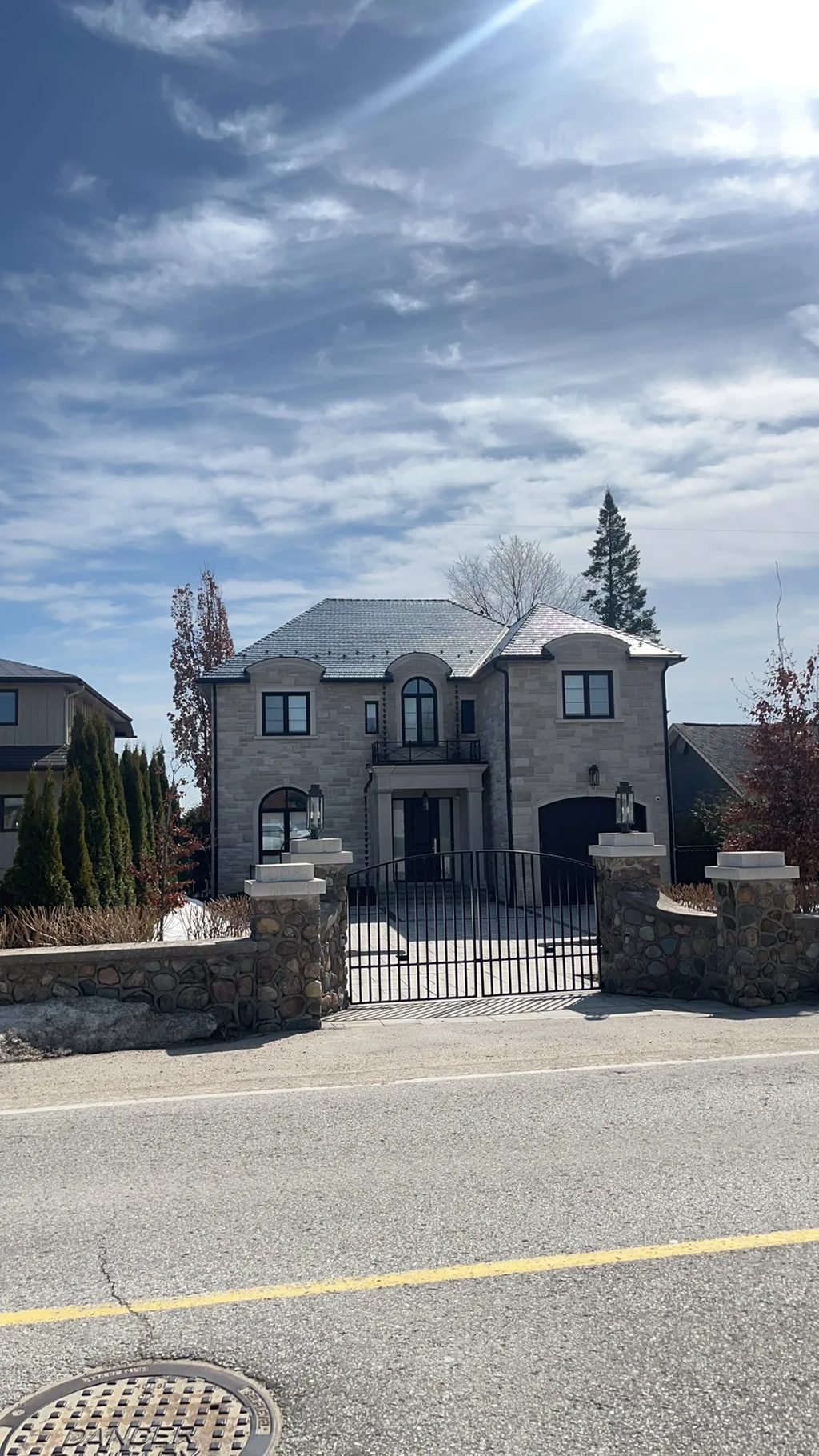Tudor Brown Interlock Slate aluminum roof on a two-storey Tudor-style home with a slate roof near a lake, Innisfil, Ontario