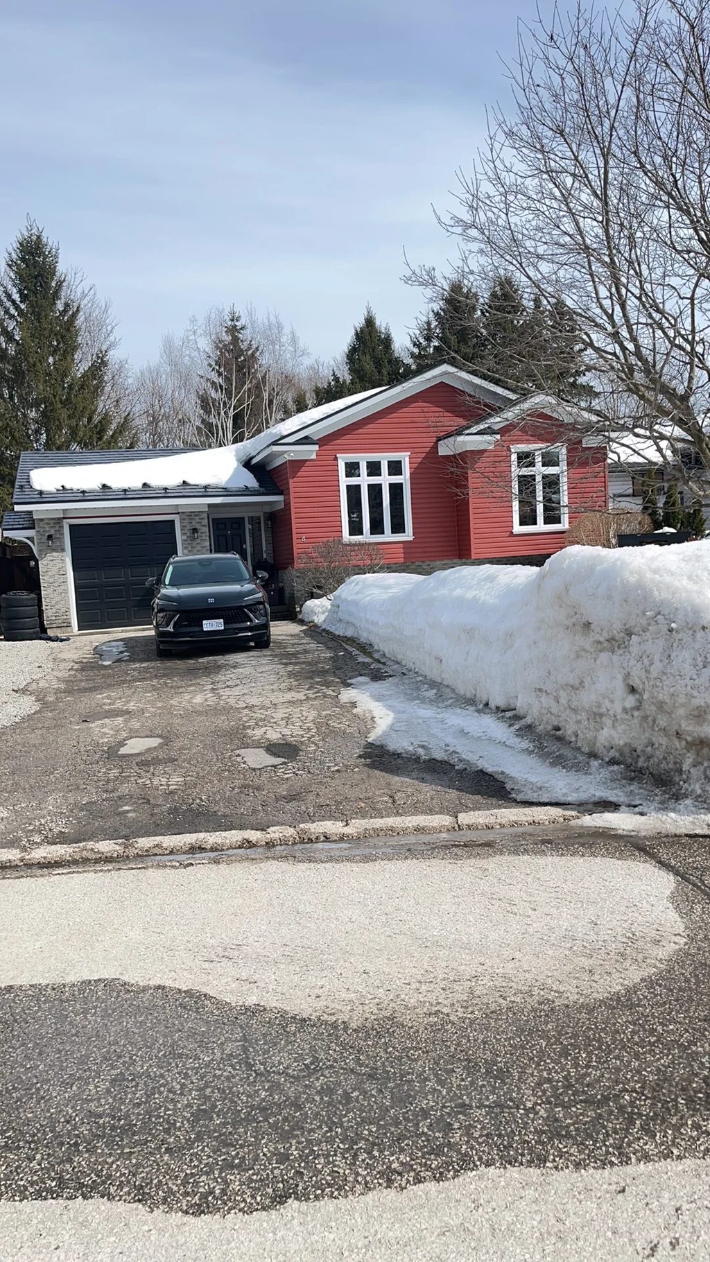 Black Interlock Slate aluminum roof on a red home with a metal roof in a snowy forest, Orillia, Ontario