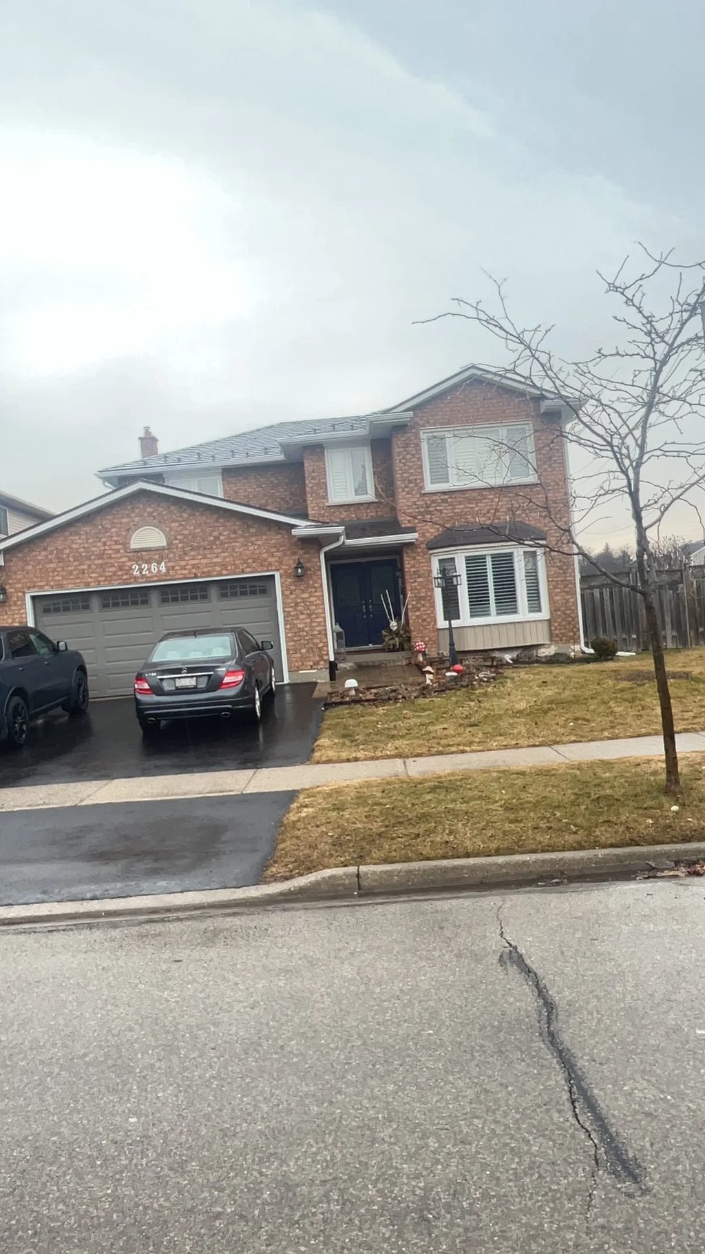 Tudor Brown Interlock Slate aluminum roof being installed on a two-storey brick home with dormers in a suburban, Burlington, Ontario