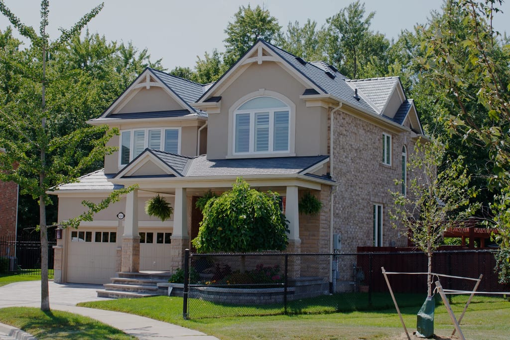 Deep Charcoal Interlock Cedar Shingle aluminum roof on a two-storey Colonial home with stone accents and a metal, Milton, Ontario