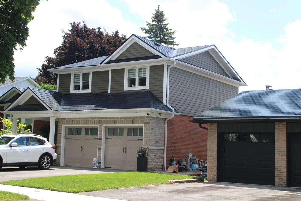 Black Interlock Slate aluminum roof on a two-storey home with grey siding and white trim among, Markham, Ontario