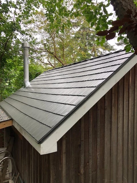 Musket Grey Interlock Cedar Shingle aluminum roof on a brown home with a grey metal roof among tall trees, Mississauga, Ontario