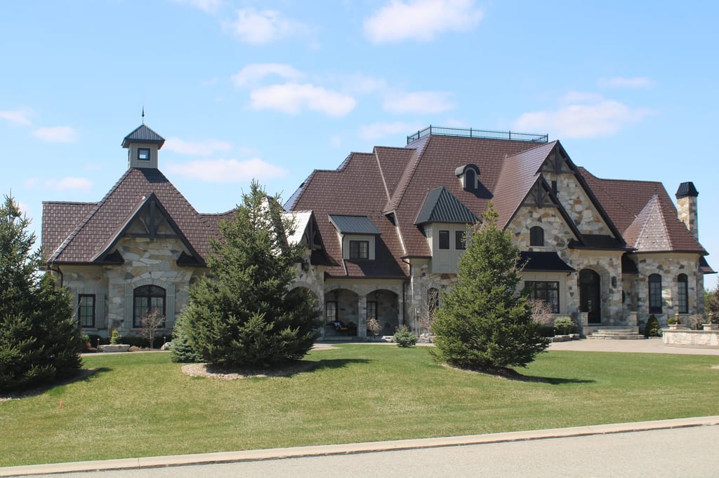 Colonial Brown Interlock Slate aluminum roof on a colonial home with a brown metal roof and stone facade in, Caledon, Ontario