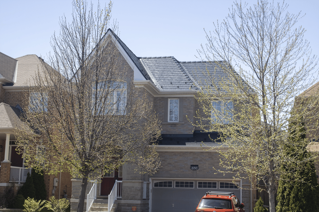 Two-storey brick home in Vaughan, ON featuring a dark charcoal Interlock aluminum slate metal roof with dormers, valleys, and snow guards.