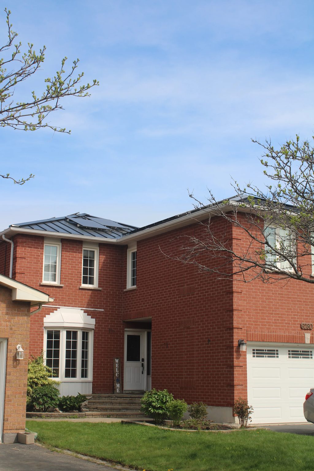 Black Interlock Standing Seam aluminum roof on a red brick two-storey colonial home with dormers, Mississauga, Ontario