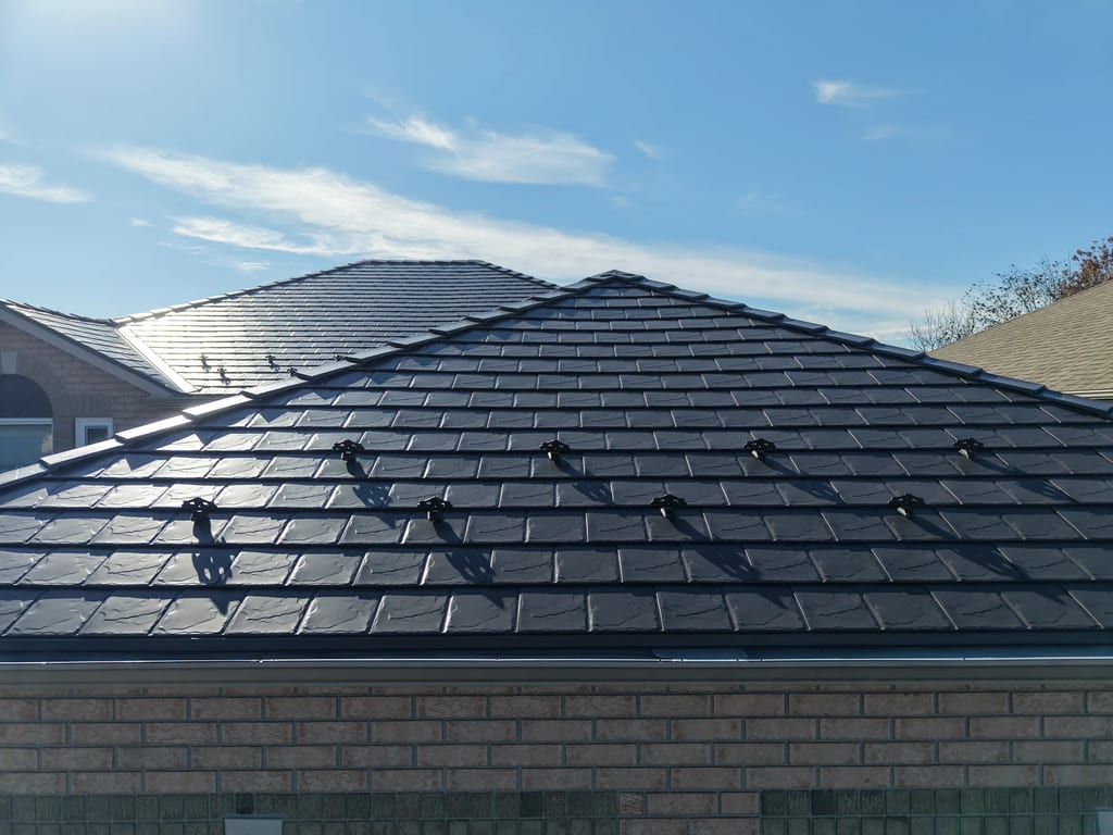 Tudor Brown Interlock Slate aluminum roof on a Tudor home with brown brick and a brown roof, Lindsay, Ontario