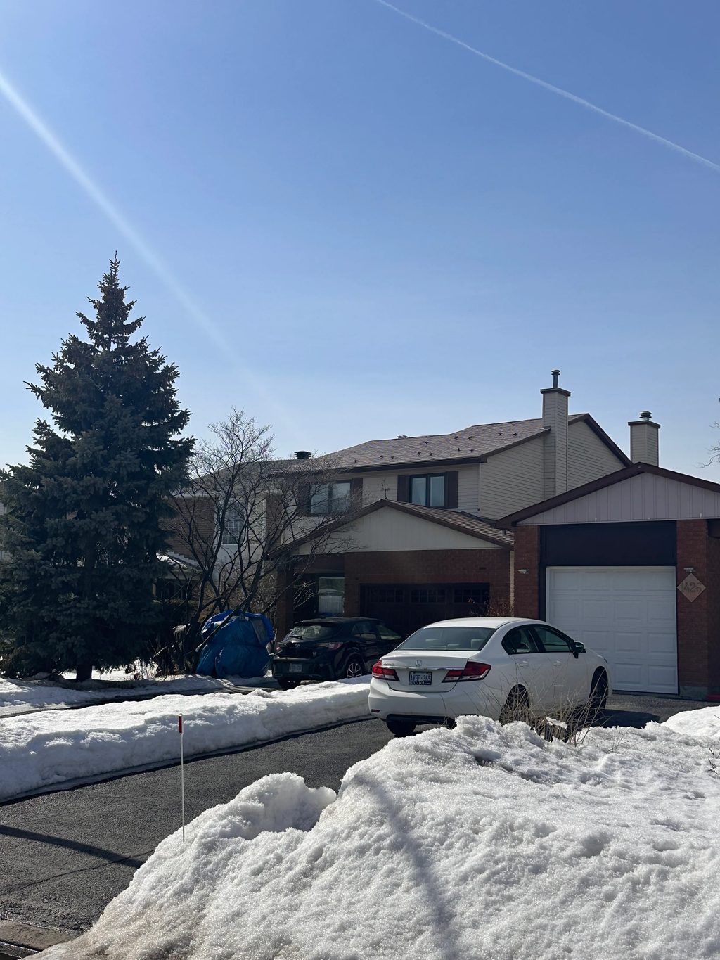 Aged Copper Interlock Shingle aluminum roof on a two-storey home with brown brick and beige siding in the, Gloucester, Ontario