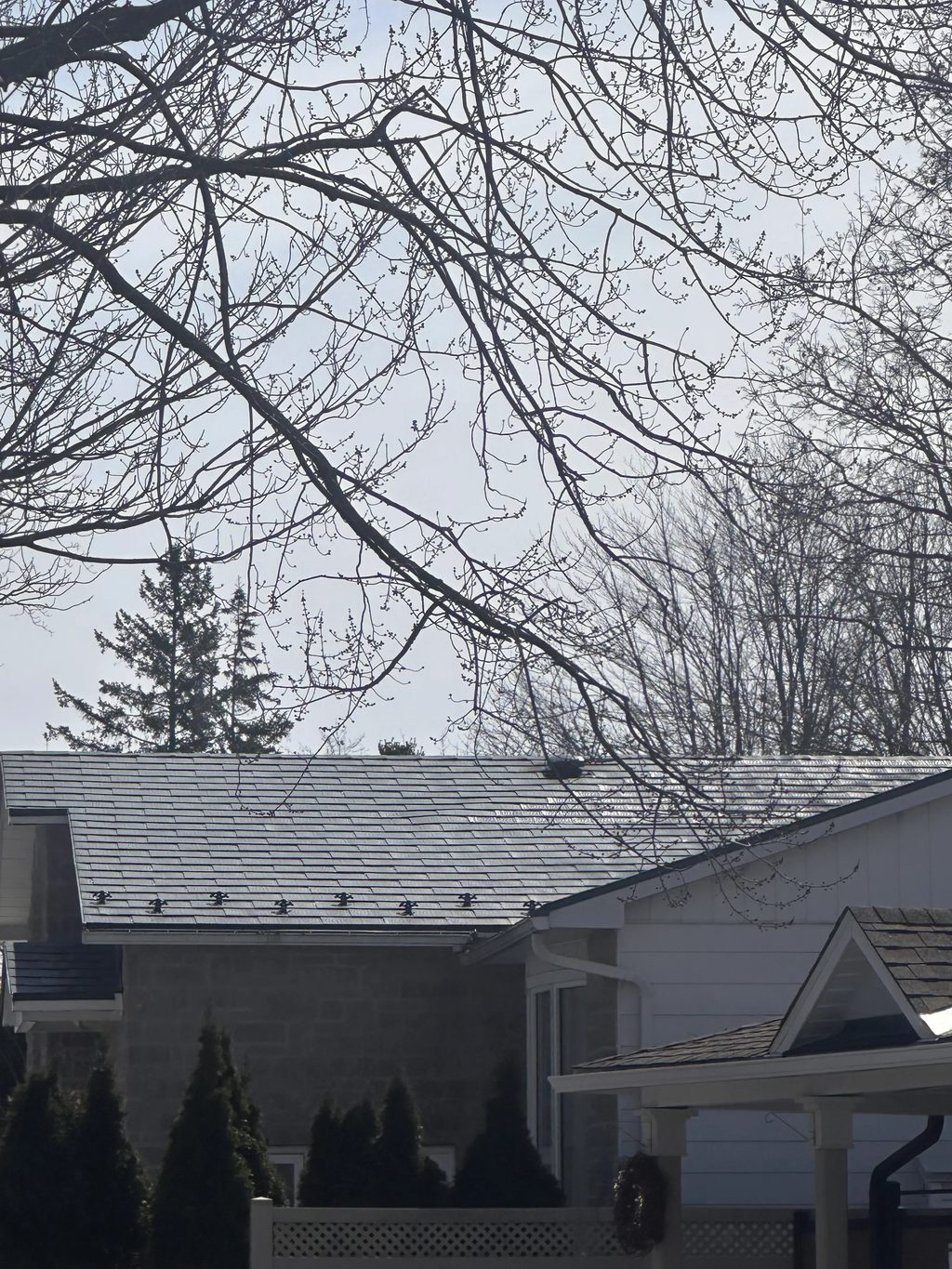 Charcoal Grey Interlock Shingle aluminum roof on a white single-family home with a gable roof in a suburban, Gloucester, Ontario