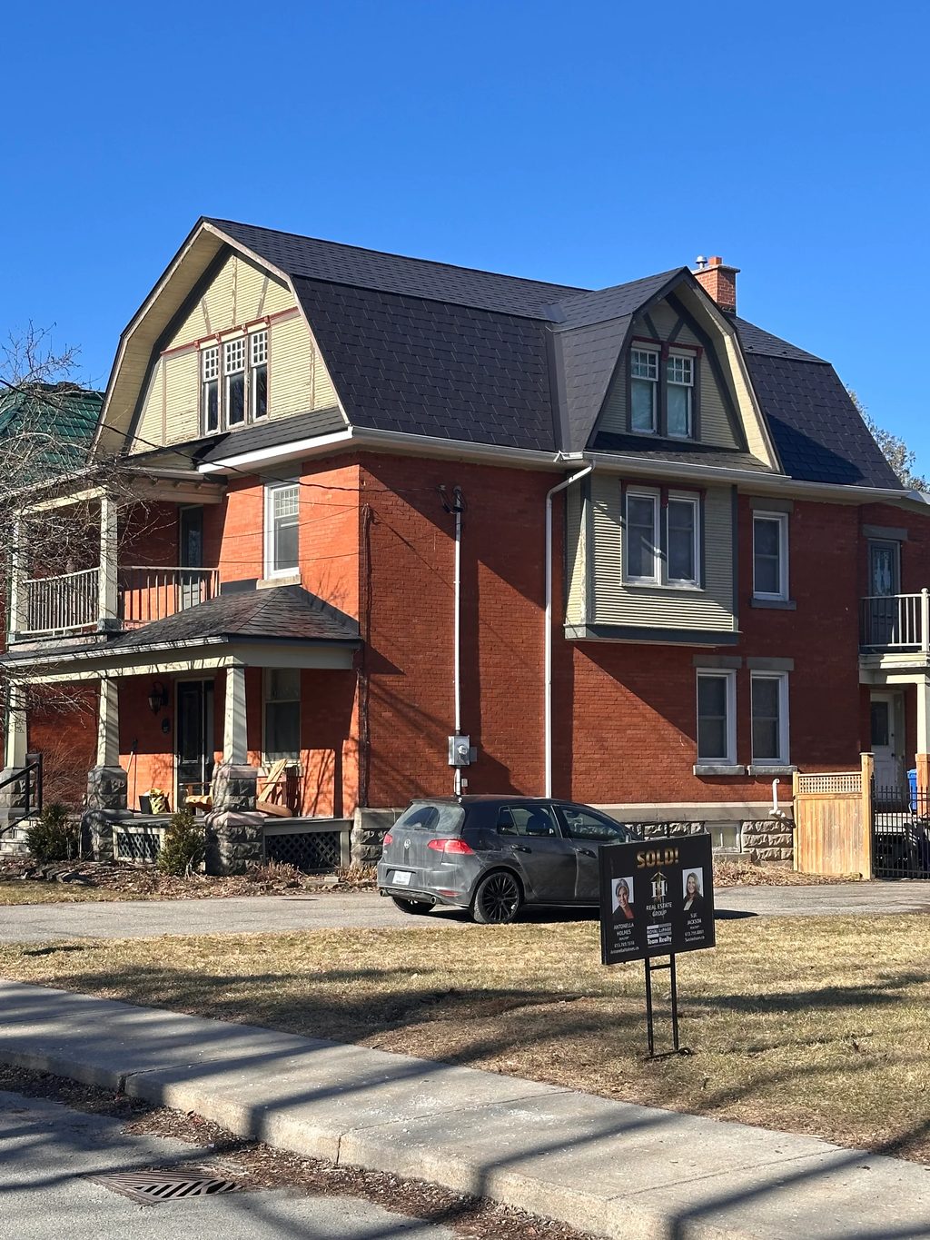 Black Interlock Slate aluminum roof on a red two-storey home with dormers in a suburban, Kemptville, Ontario