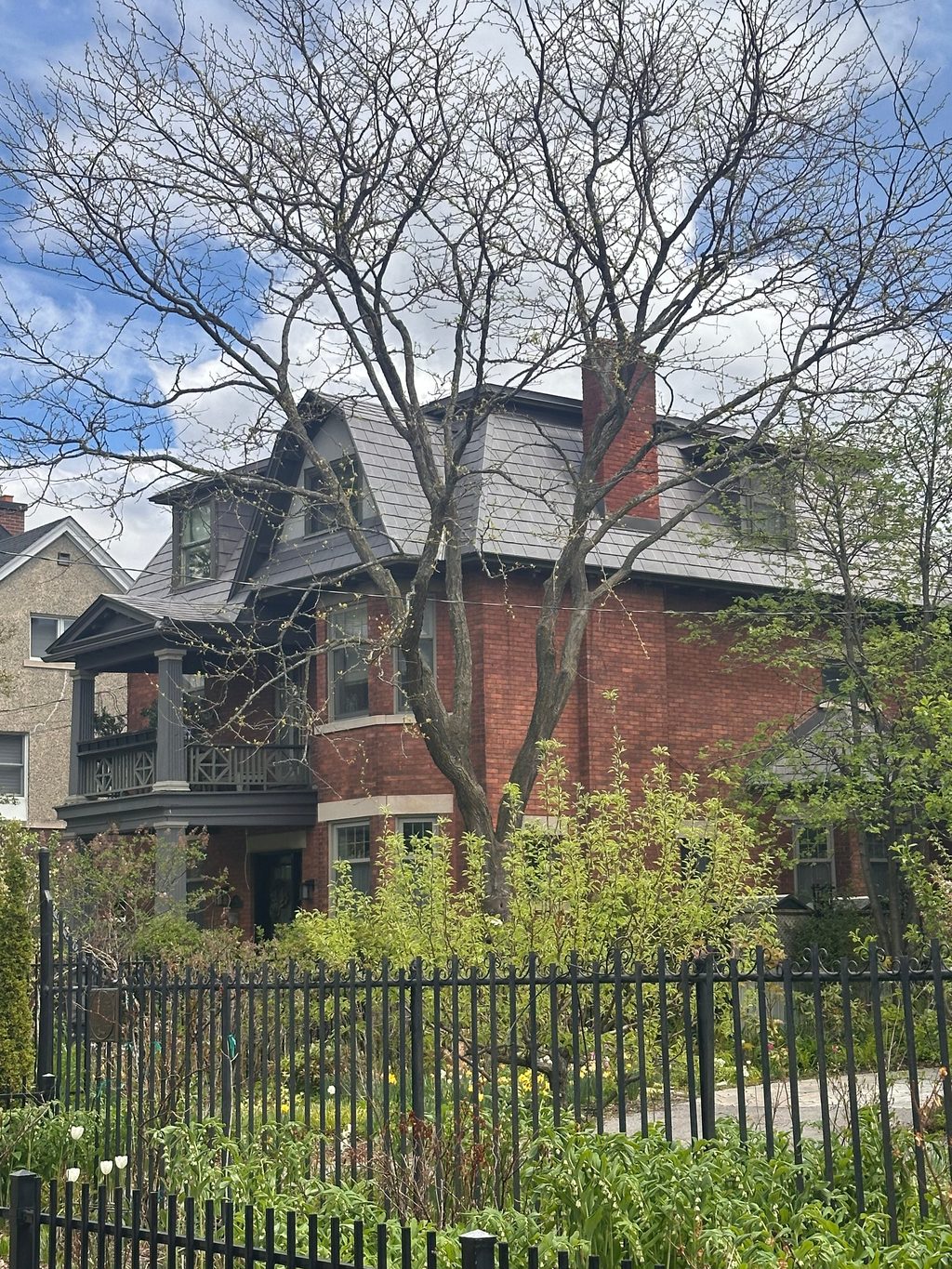 Victorian red-brick home in Ottawa with Interlock Musket Grey aluminum slate roofing, steep multi-hip profile, dormers, and chimney, viewed from street.