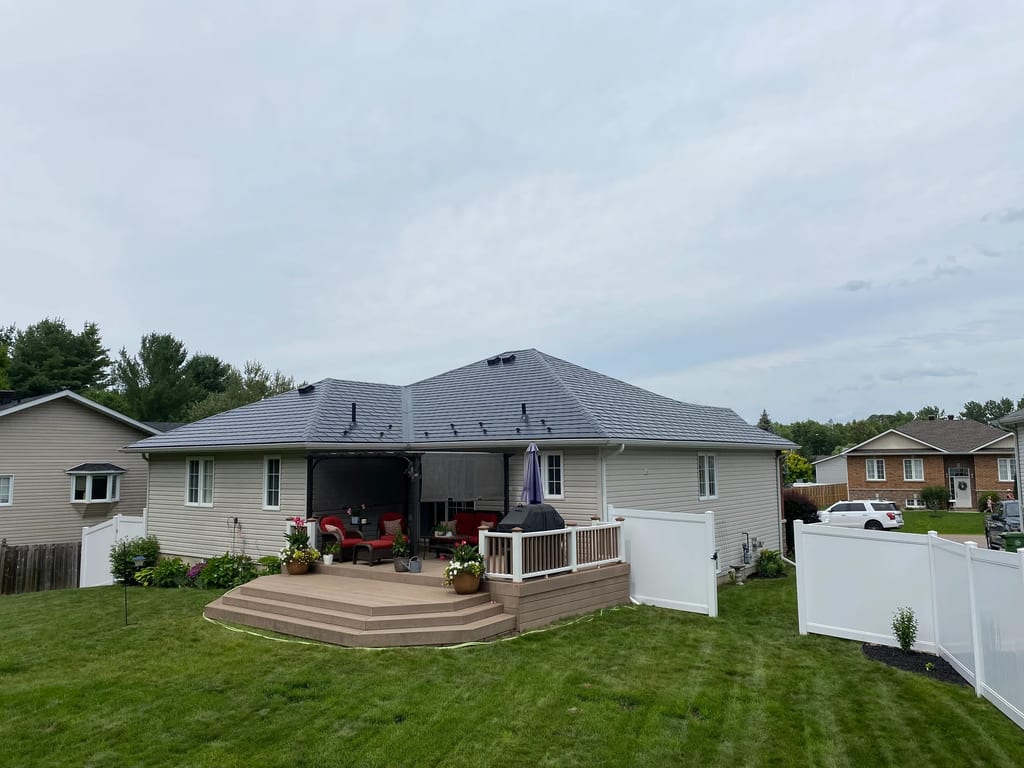 Black Interlock Slate aluminum roof on a house with a grey roof and beige siding in a rural, Pembroke, Ontario