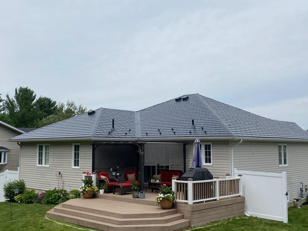 Black Interlock Slate aluminum roof on a beige ranch home with a grey metal roof in a rural area, Pembroke, Ontario