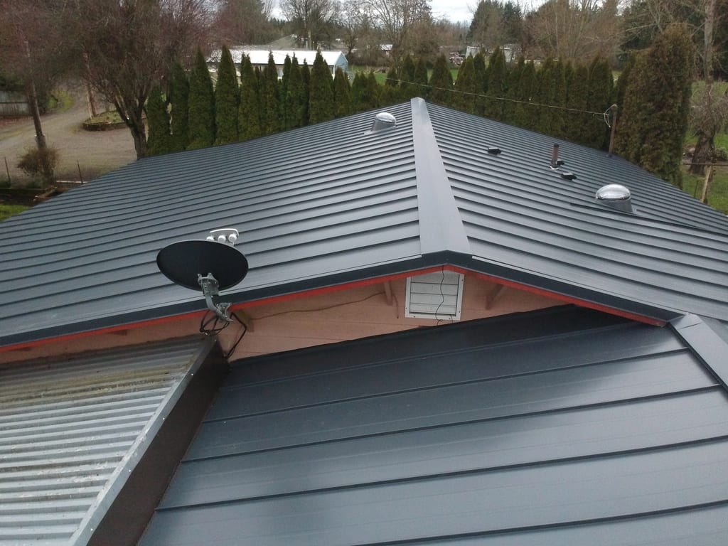 Deep Charcoal Interlock Standing Seam aluminum roof on a dark roof on a house with dormers in a forested rural, Scio, Oregon