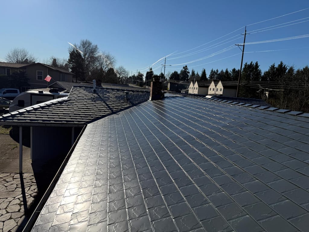 Deep charcoal Interlock aluminum slate metal roofing on a single-family ranch home in Beaverton, OR, showing full roof with chimney and valley details.