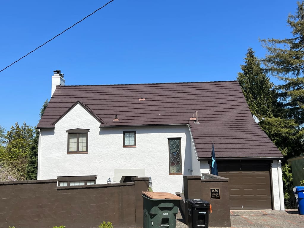 Colonial Brown Interlock Shake aluminum roof on a colonial home with a metal roof among tall evergreens, Seattle, Washington