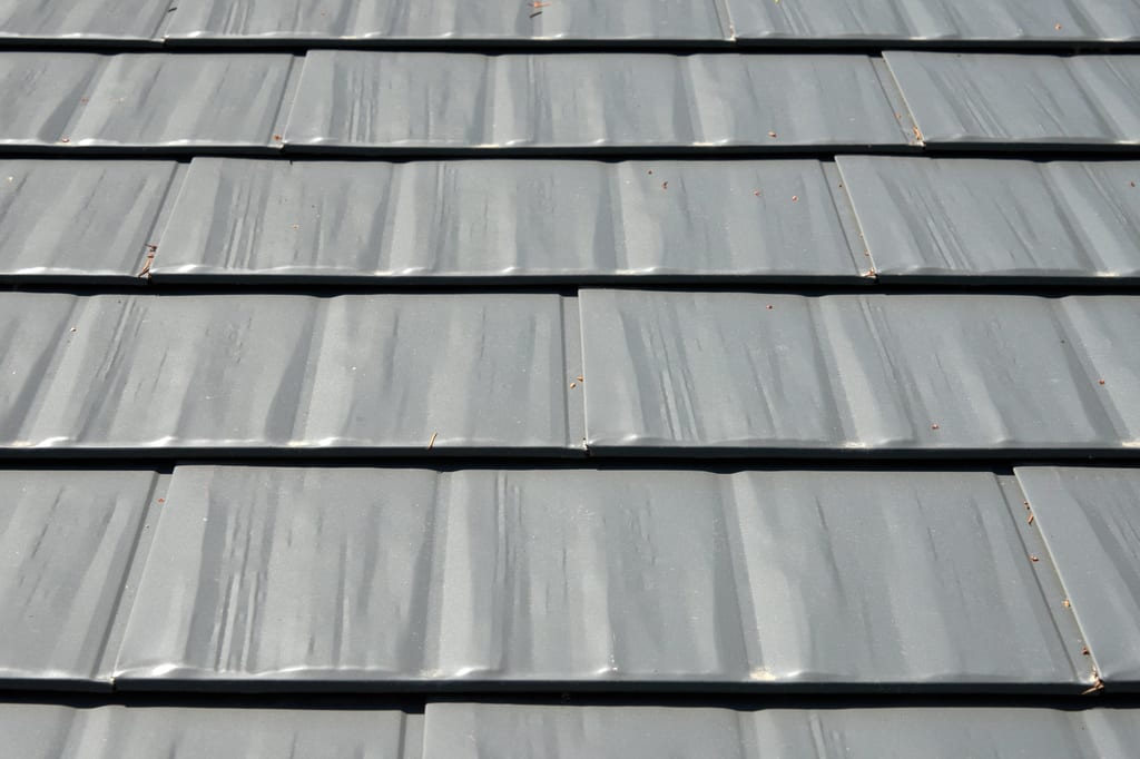 Musket Grey Interlock Cedar Shingle aluminum roof on a grey two-storey home with a modern metal roof among trees, Arlington, Washington