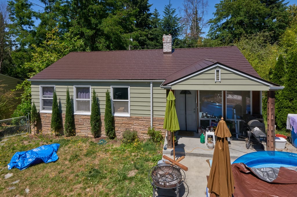 Colonial Brown Interlock Cedar Shingle aluminum roof on a Colonial-style home with a brown roof and green siding in, Shoreline, Washington